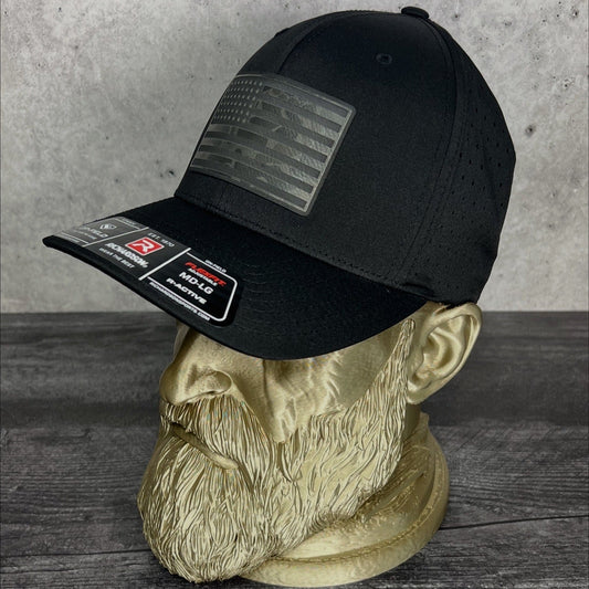 Black cap with patches on a mannequin head against a concrete wall.