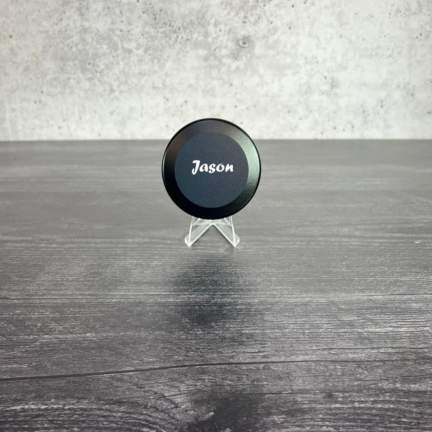 Black circular object with 'Jason' branding on a wooden surface