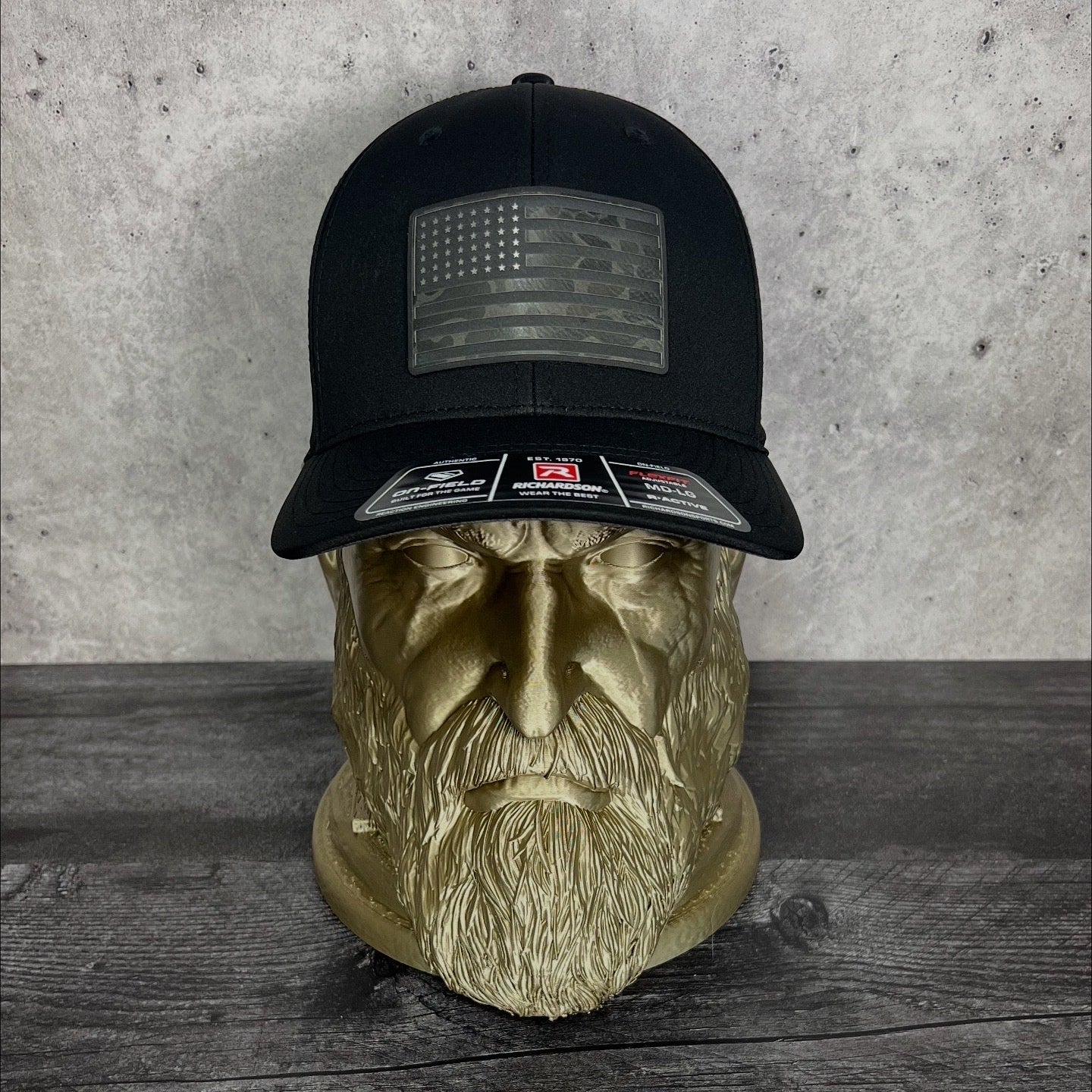 Black cap with American flag patch on a wooden surface