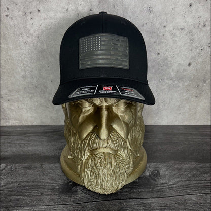 Black cap with American flag patch on a wooden surface