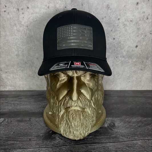 Black cap with American flag patch on a wooden surface