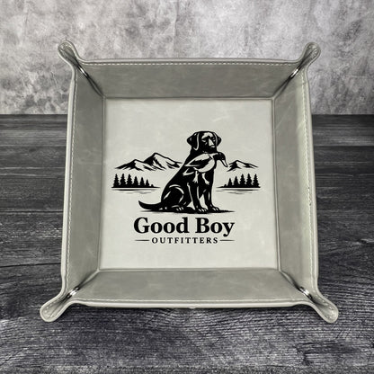 Grey valet tray with 'Good Boy Outfitters' logo on a wooden surface