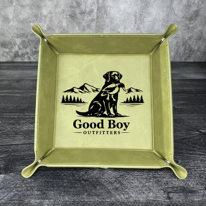 Olive leather tray with 'Good Boy Outfitters' logo on a gray surface