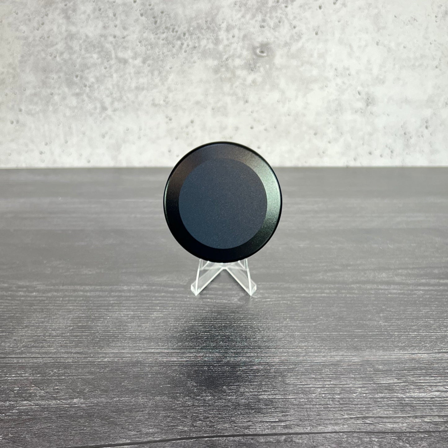 Black circular object on a textured surface