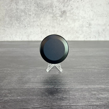 Black circular object on a textured surface