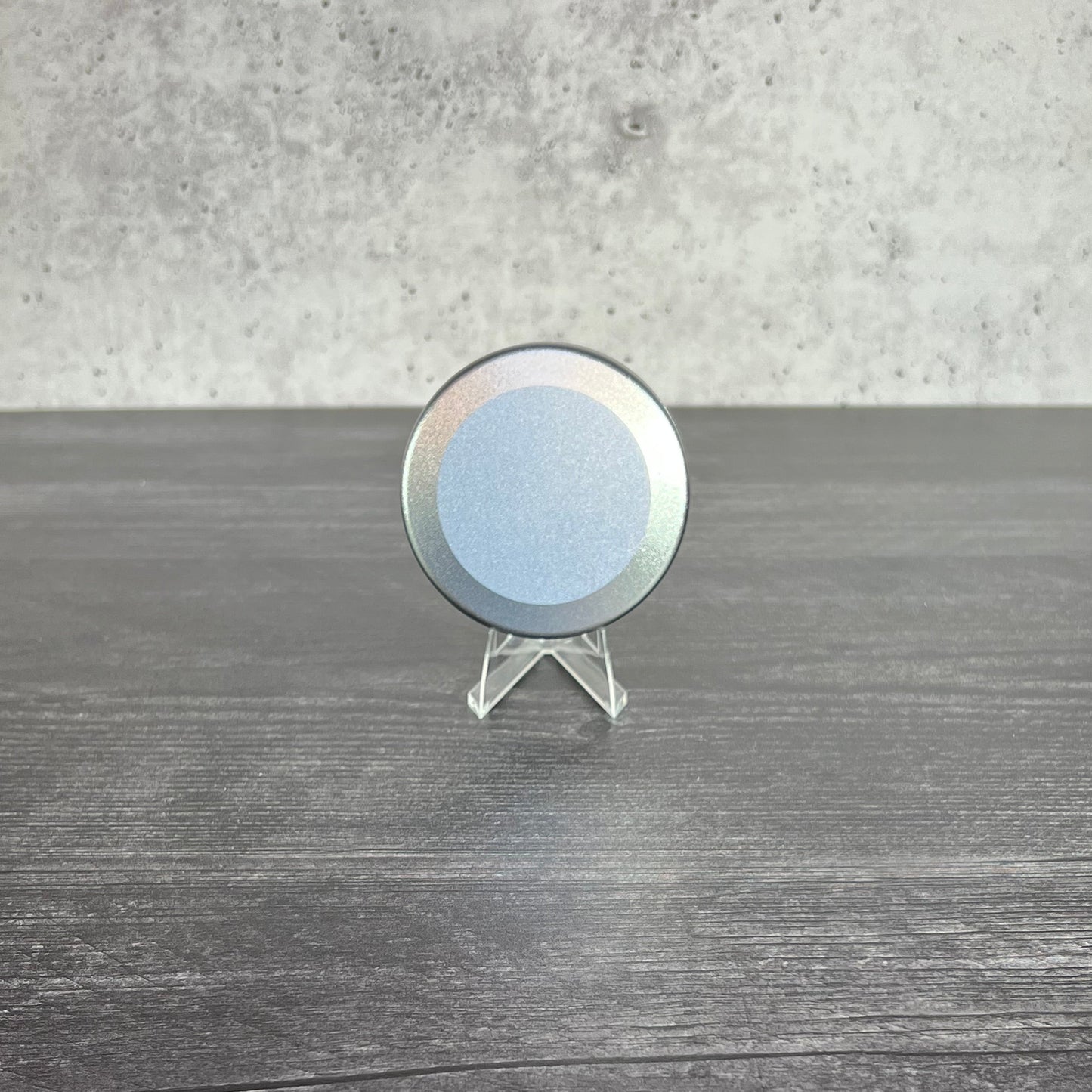 Round metallic object on a wooden surface