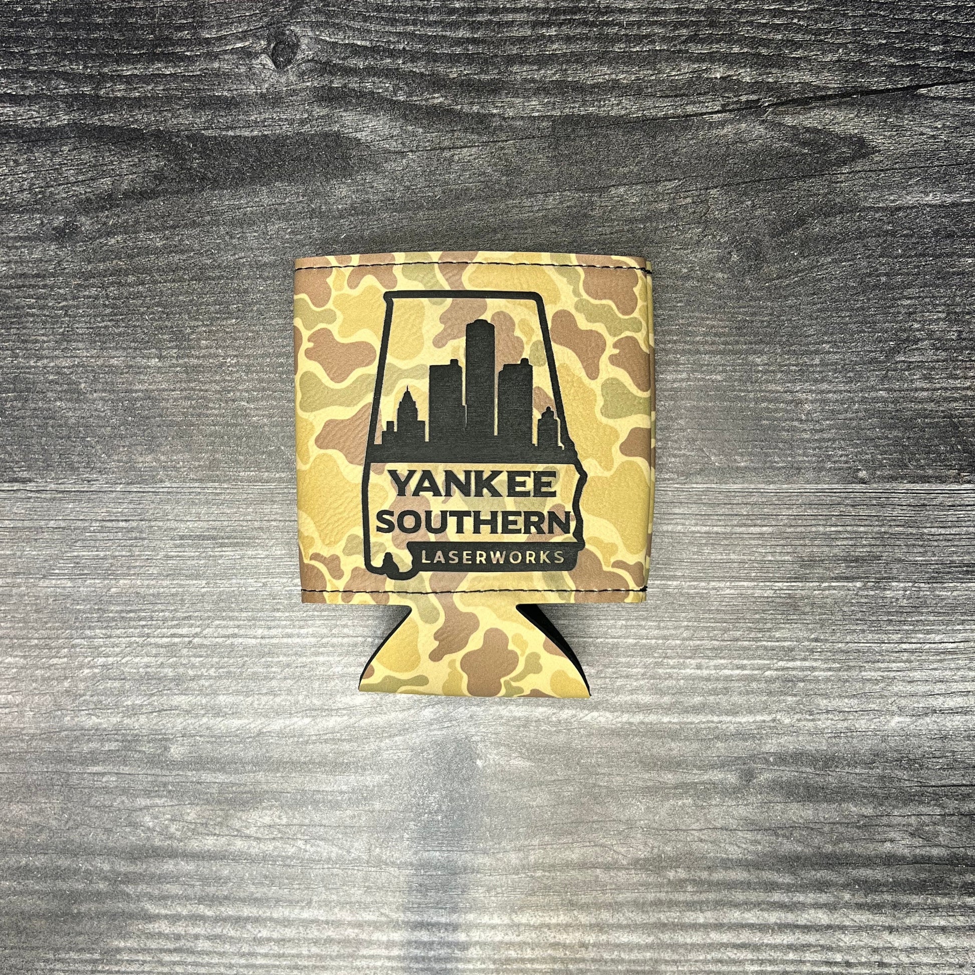 Camo-patterned can cooler with 'Yankee Southern' logo on a wooden surface
