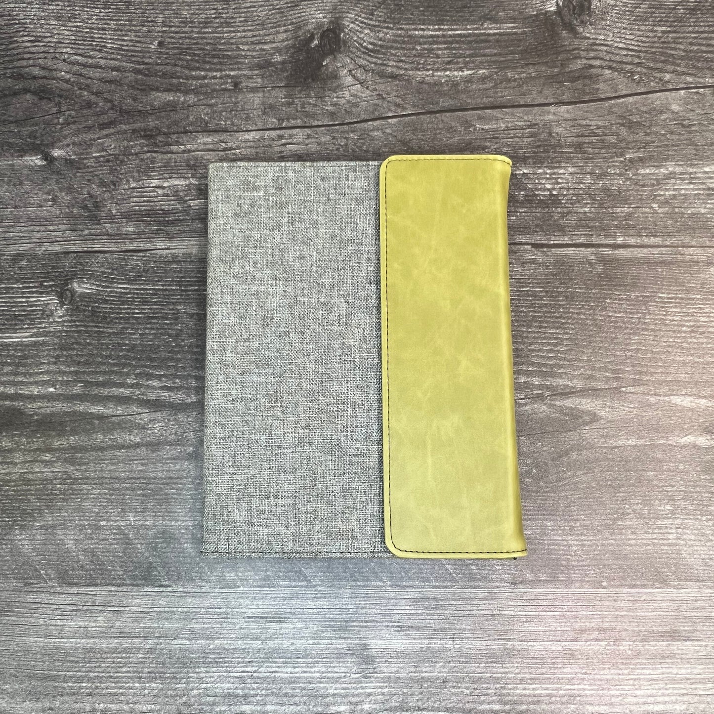 Two rectangular cloths, one gray and one yellow, on a wooden surface.