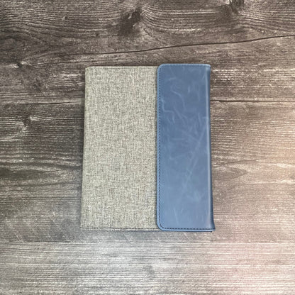 Two rectangular pouches, one gray and one blue, on a wooden surface.