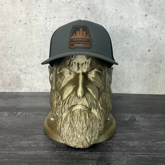 Yankee Southern Laserworks 5 panel hat with walnut colored branded patch on a gold statue.